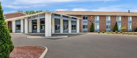 A Comfort Inn hotel with a central entrance, a brick building, and a parking lot.
