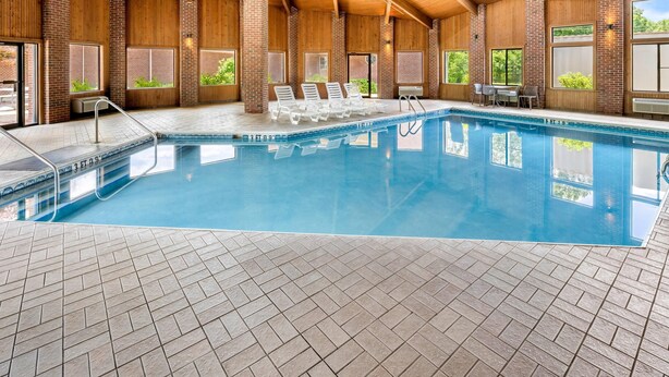 An indoor swimming pool with a tiled floor, wooden ceiling, and brick walls. - Comfort Inn Mount Vernon Downtown (Mount Vernon)