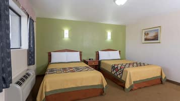 A hotel room with two beds, a window with curtains, a wall-mounted heater, and a painting on the wall.