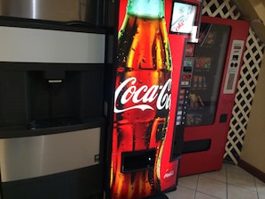 A vending machine with a Coca-Cola logo, a digital display, and a coin slot. - America's Best Inn and Suites Flowood (Flowood)