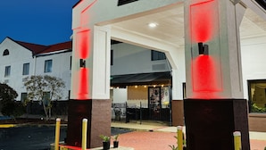 A building with a large entrance, a covered area, and a Christmas tree in the background. - America's Best Inn and Suites Flowood (Flowood)
