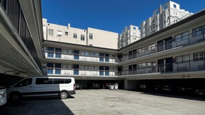 A multi-level parking garage with several parked vehicles, including a white van. - Motel 6 San Francisco, CA - Fisherman's Wharf (San Francisco)
