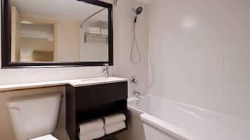 Une salle de bain avec un lavabo blanc, un meuble-lavabo foncé, des toilettes blanches et une baignoire blanche.