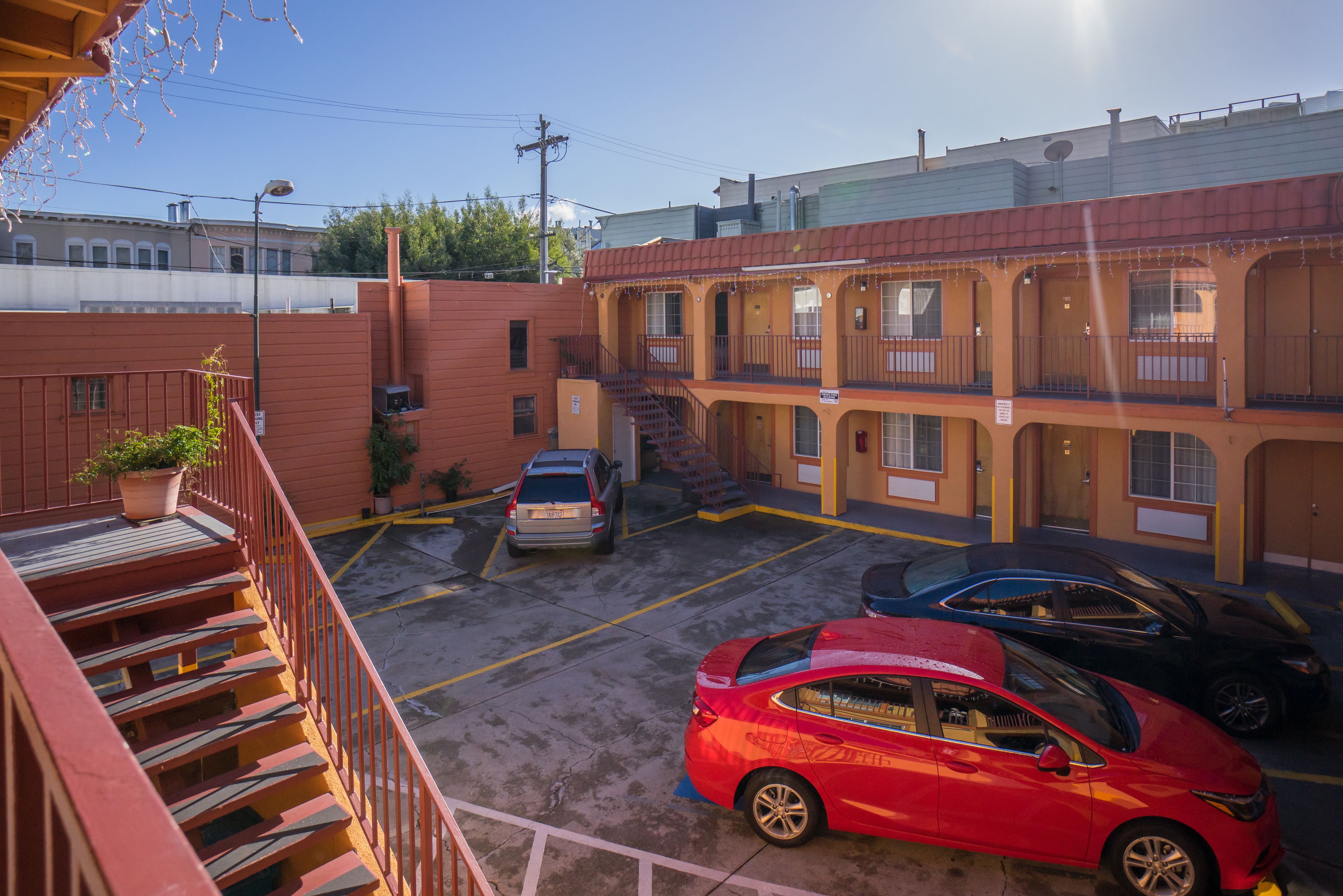 A multi-story building with a parking area in front.