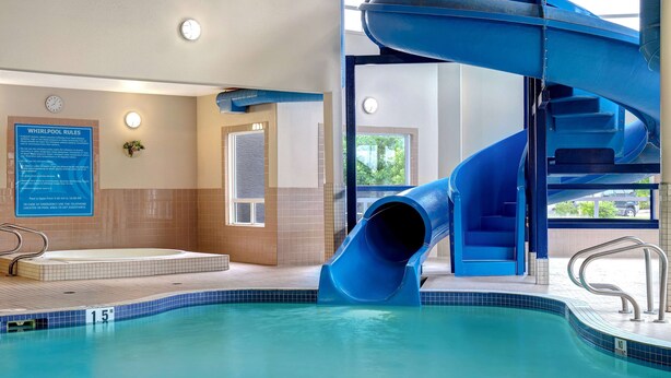A pool with a blue slide and a whirlpool area.
