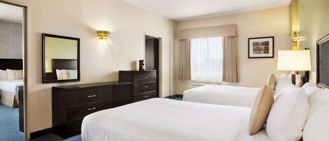 A hotel room with two beds, a dresser, a mirror, and a window with curtains.