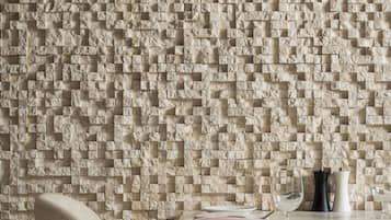 Een modern interieur met een structuurwand, een eettafel en een stoel.