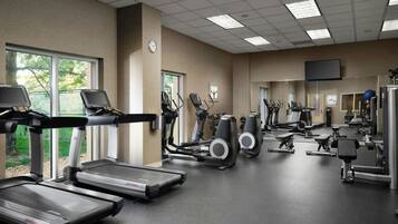 A gym with treadmills, exercise bikes, and weight machines.
