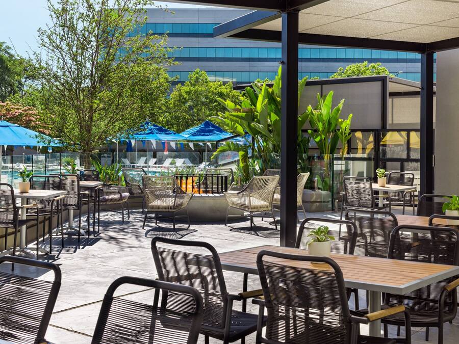 Un espace extérieur aménagé avec des tables et des chaises, une piscine et des parasols.