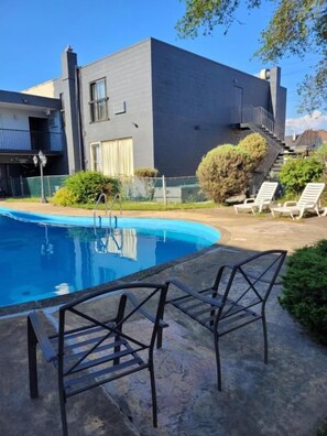 A modern building with a swimming pool, outdoor seating, and a staircase leading to the upper levels. - 7 Nights Stay (Niagara Falls)