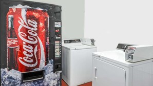 A vending machine with a Coca-Cola design, a washing machine, and a dryer. - Knights Inn London (London)