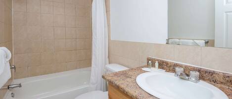 Un baño con bañera, inodoro y lavamanos.