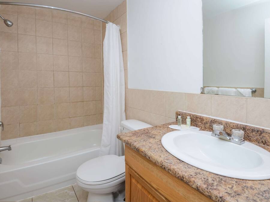 A bathroom with a bathtub, toilet, and sink.