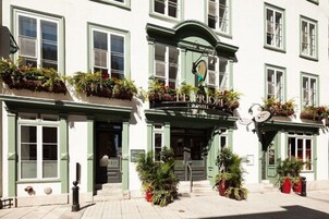 Un edificio tradicional con fachada verde, múltiples ventanas y un letrero que dice "LE PRINCI MOTEL".