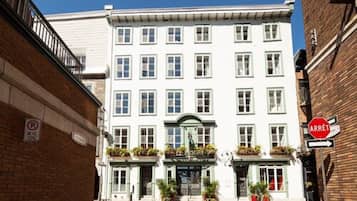 Un bâtiment blanc avec une entrée verte et une enseigne sur laquelle on peut lire « HÔTEL ».