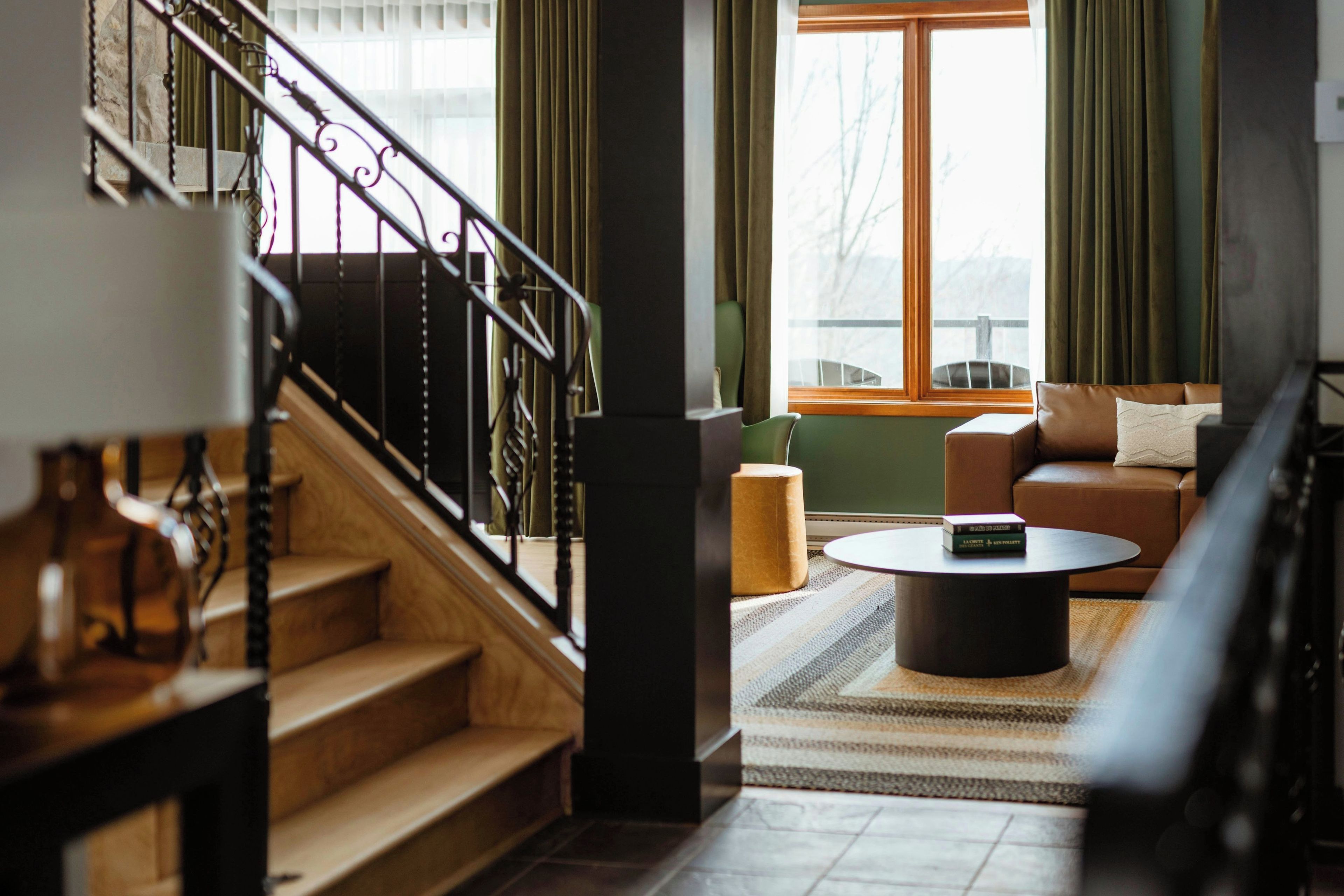 A staircase leading to a living area with a sofa, a coffee table, and a view of the outdoors.