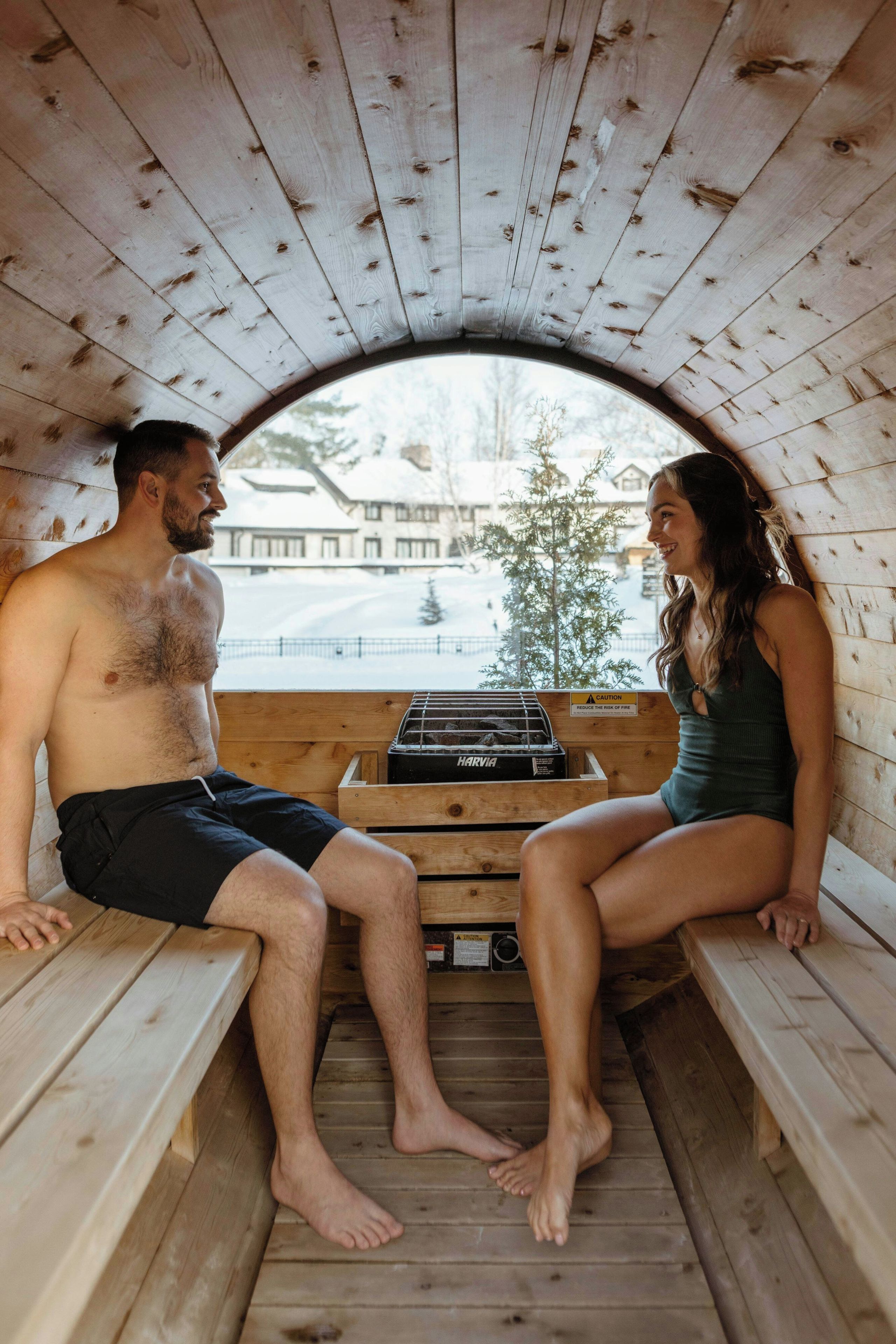 Eine Sauna mit Holzbänken und einem Harvia Saunaofen in der Mitte.