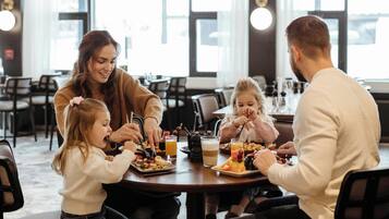 A family dining at a restaurant with a modern interior, large windows, and a casual setting.