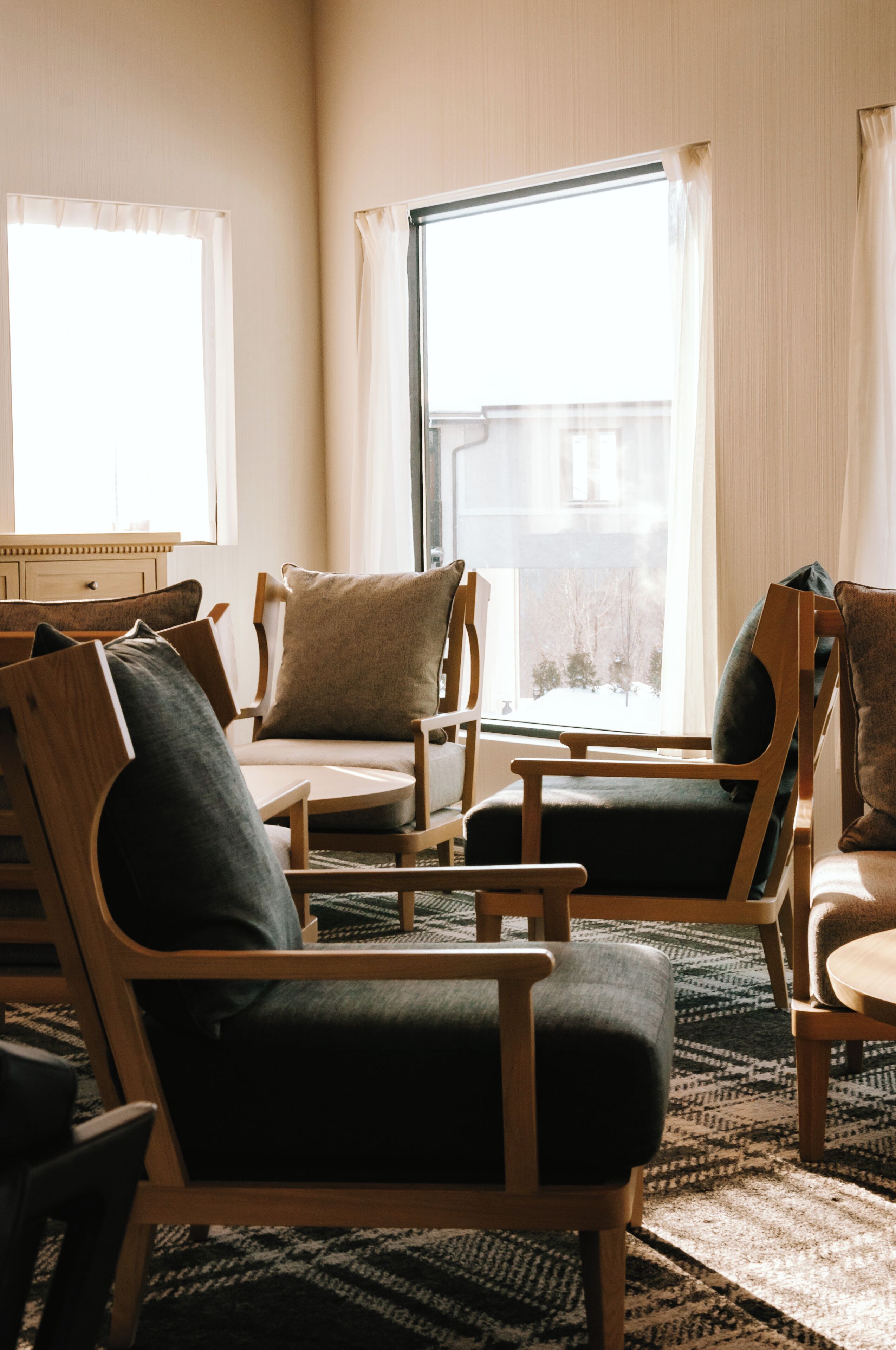 A room with wooden chairs and a large window.