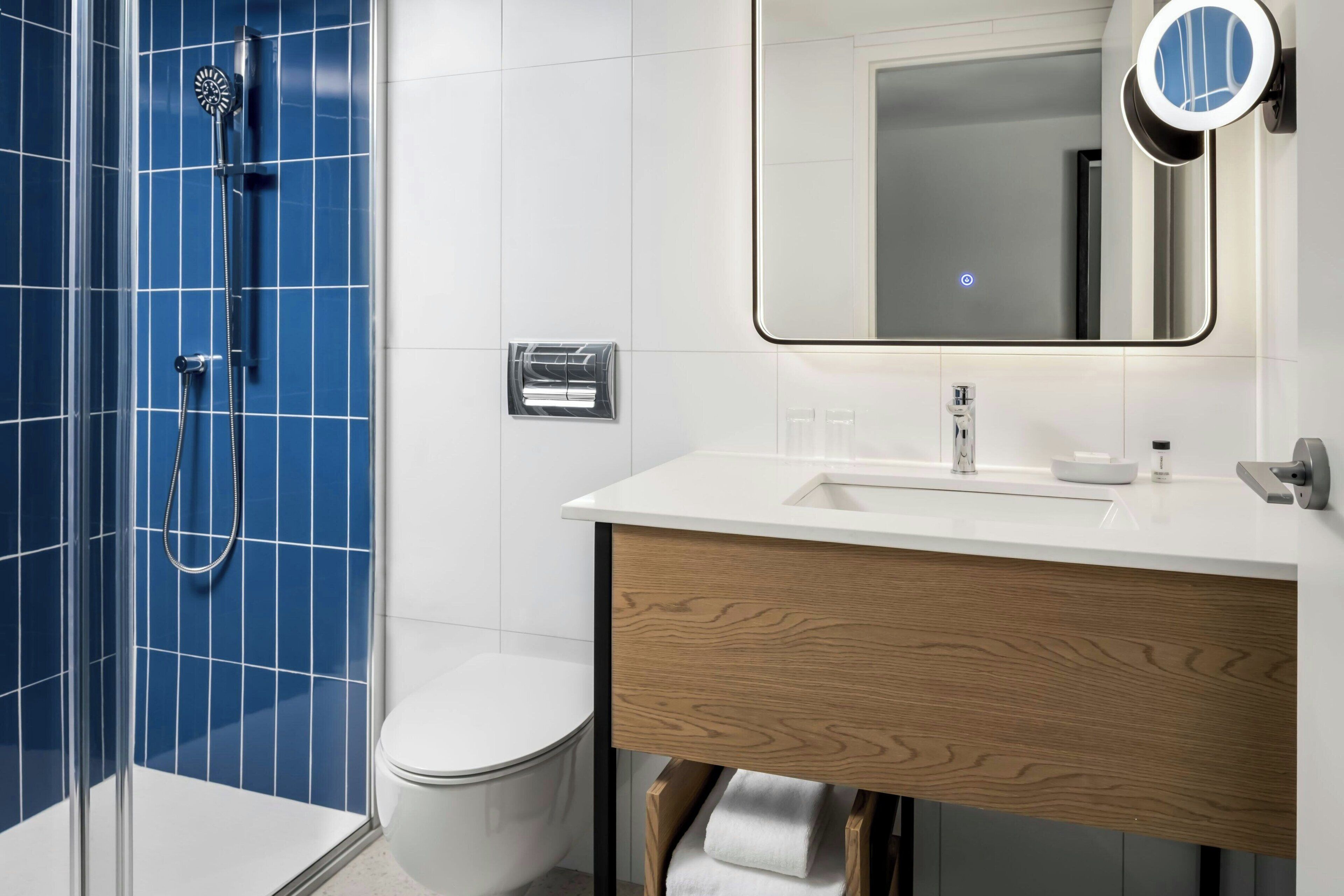 A modern bathroom with a shower, toilet, and vanity.