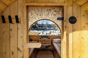 Una sauna de madera con bancos y vistas a un paisaje nevado.