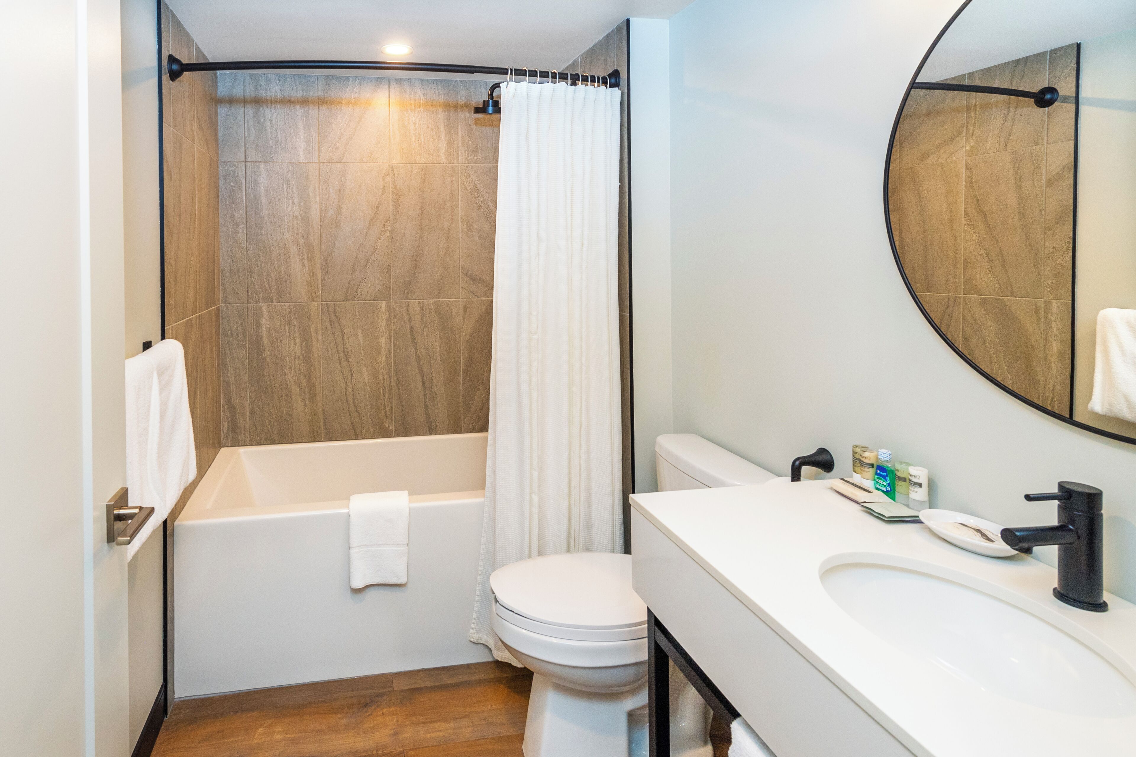 A modern bathroom with a bathtub, toilet, and sink.