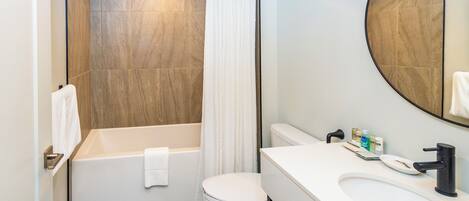 A modern bathroom with a bathtub, toilet, and sink.