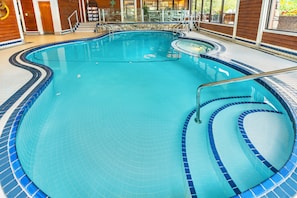 An indoor swimming pool with tiled edges and a metal ladder.