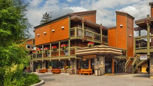A multi-story building with a wooden facade, balconies with red flowers, and a sign reading "Charltons". - Charltons Banff (Banff)