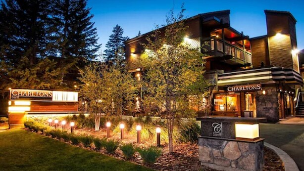 A modern building with a sign reading "CHARLTONS" and a restaurant with outdoor seating. - Charltons Banff (Banff)
