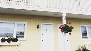 A two-story building with a balcony, a Canadian flag, and potted plants.