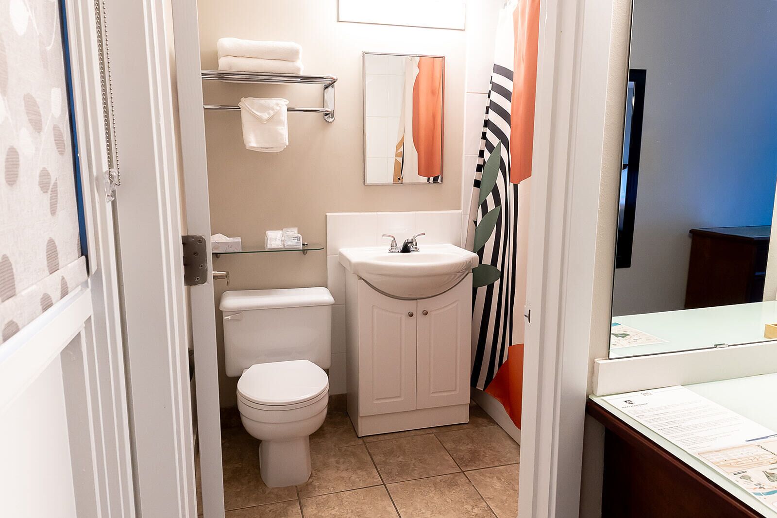 A compact bathroom with a toilet, a sink, and a mirror.