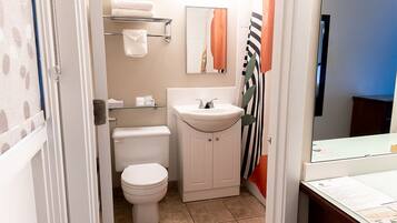 A compact bathroom with a toilet, a sink, and a mirror.