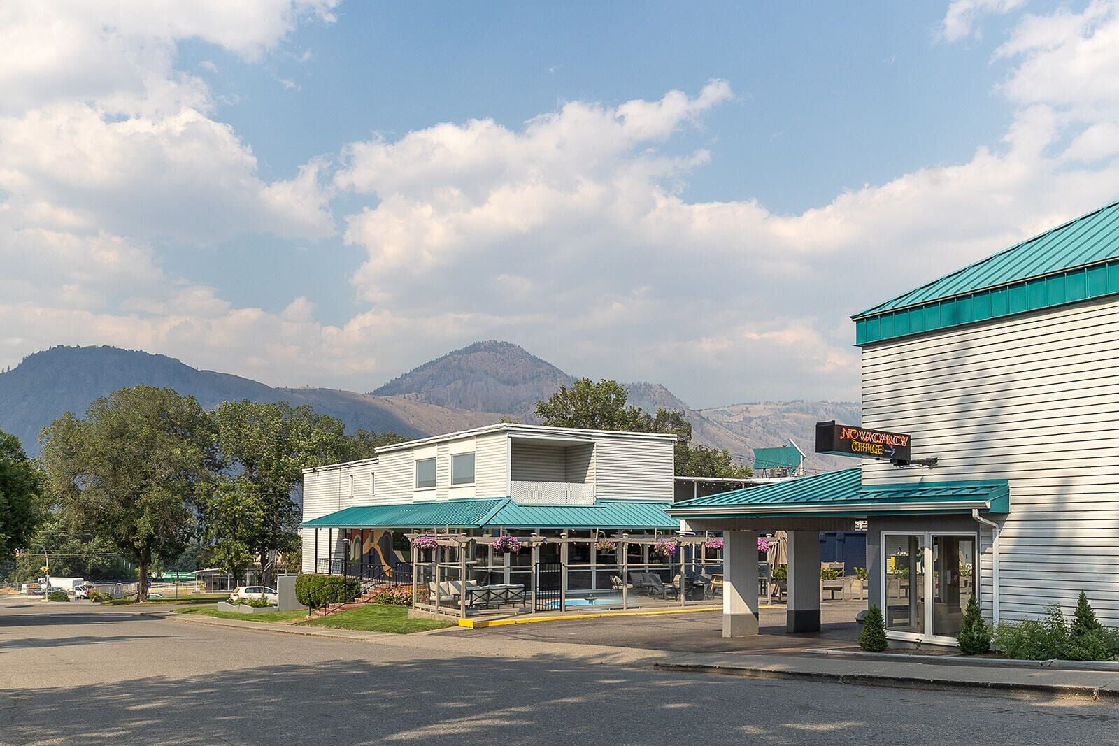 A two-story building with a green roof and a sign for a vacancy office.