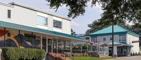 A two-story building with a covered outdoor area, a staircase, and a 'No Vacancy' sign.