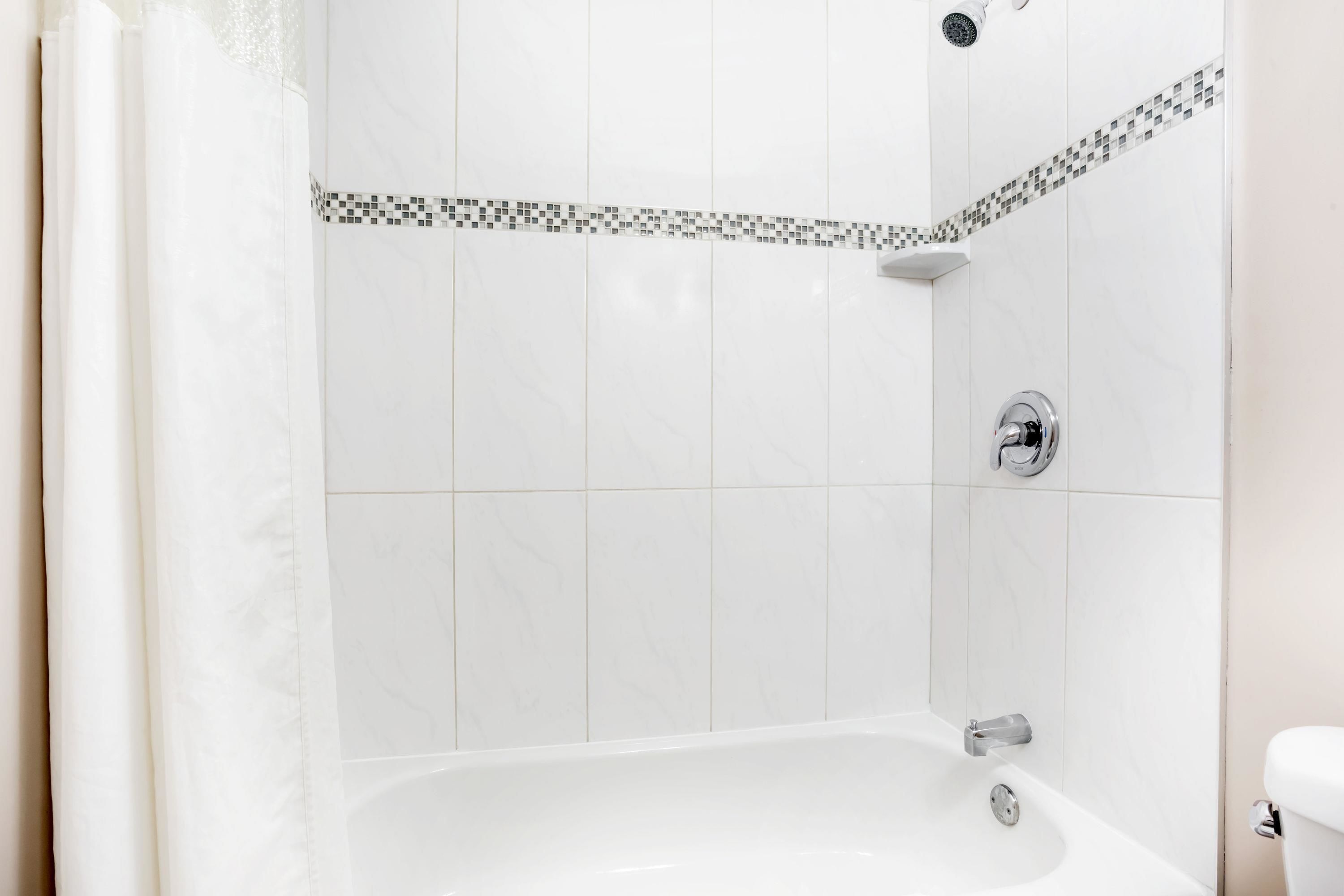 Un baño moderno con bañera, ducha y retrete.