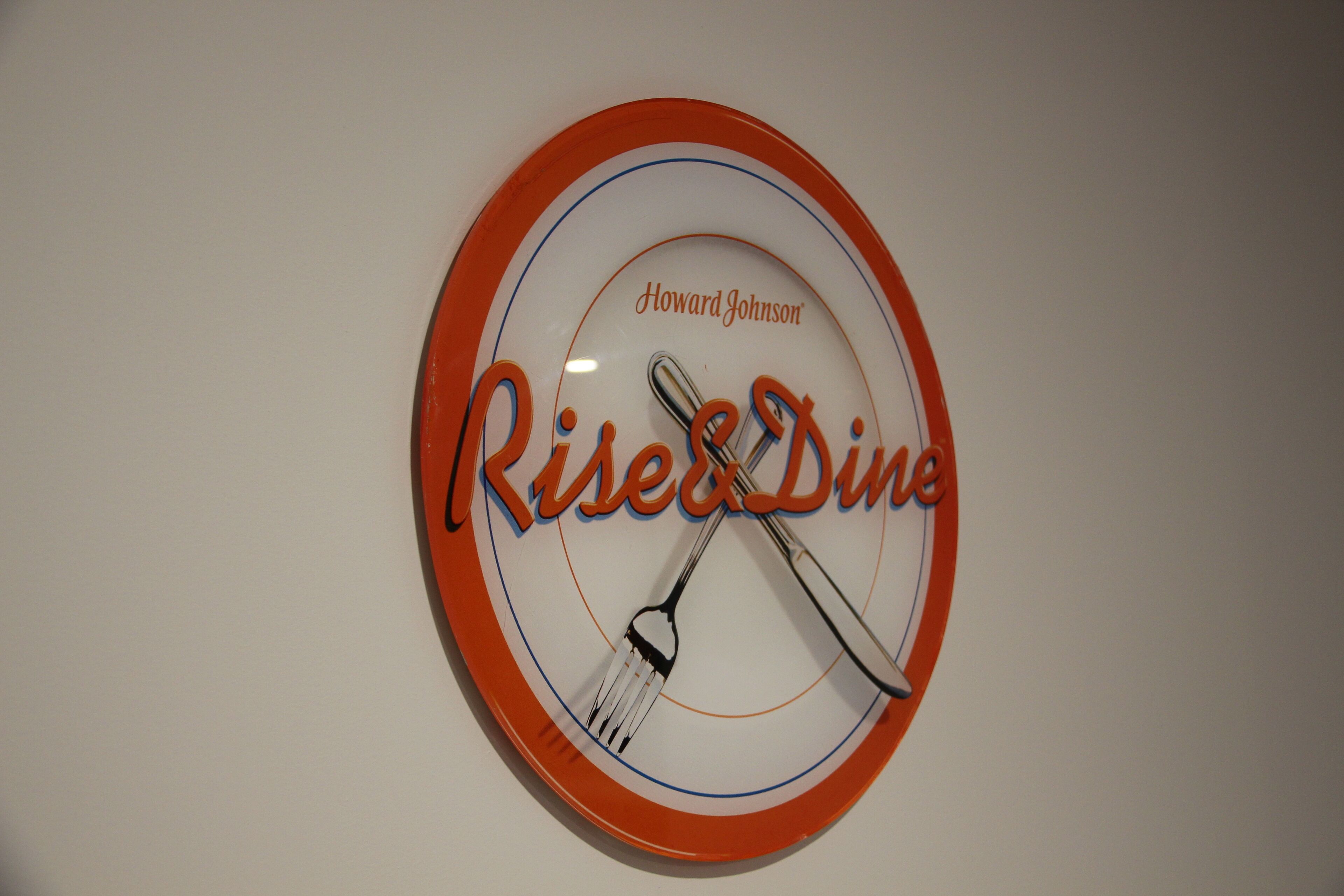 A clock with the words "Risen & Dine" and "Howard Johnson" on it.