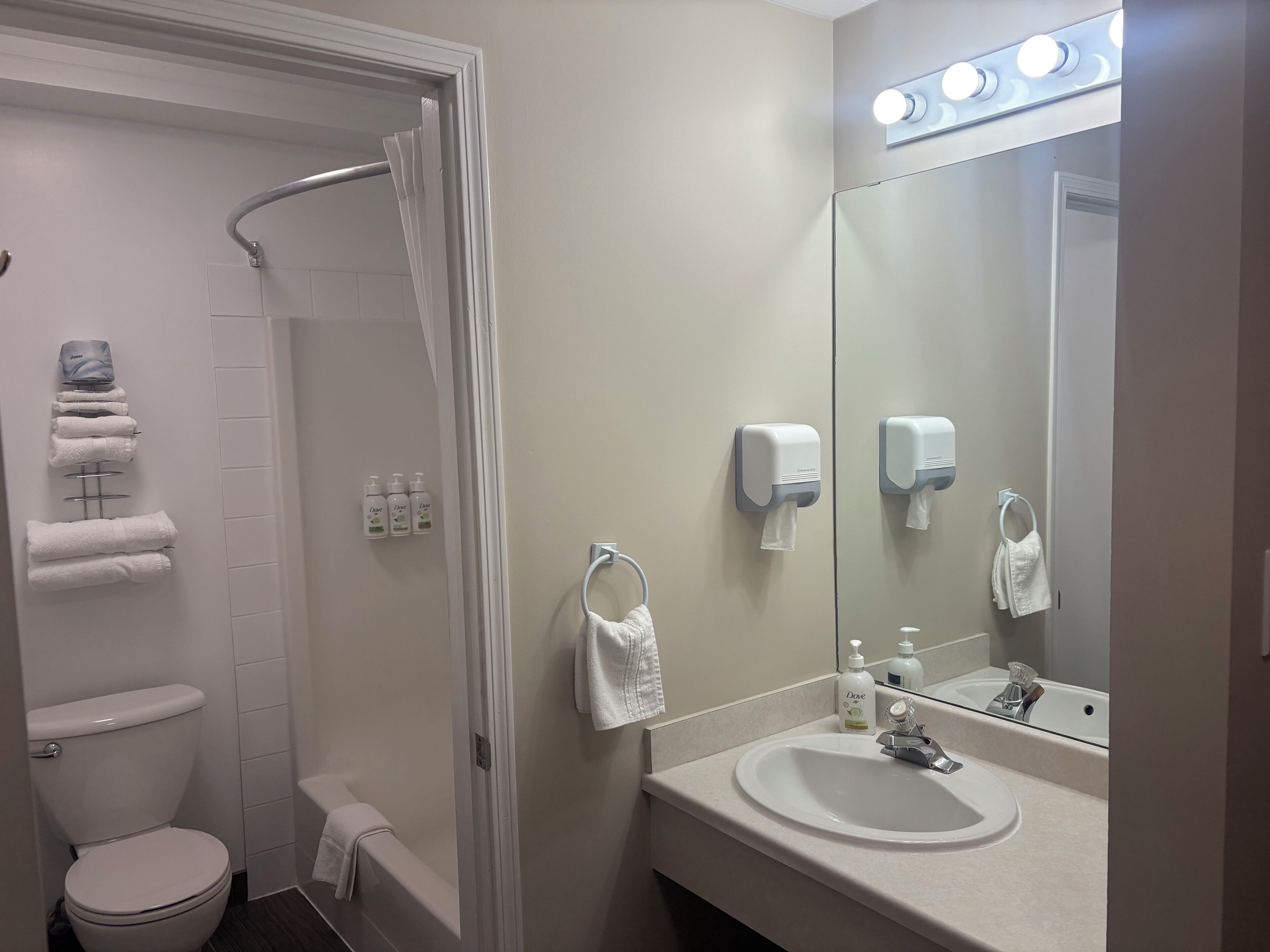 A bathroom with a toilet, sink, towel rack, and shower curtain.
