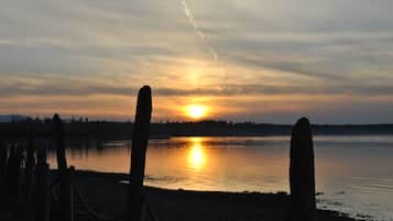 A sunset over a calm lake with a wooden fence in the foreground.