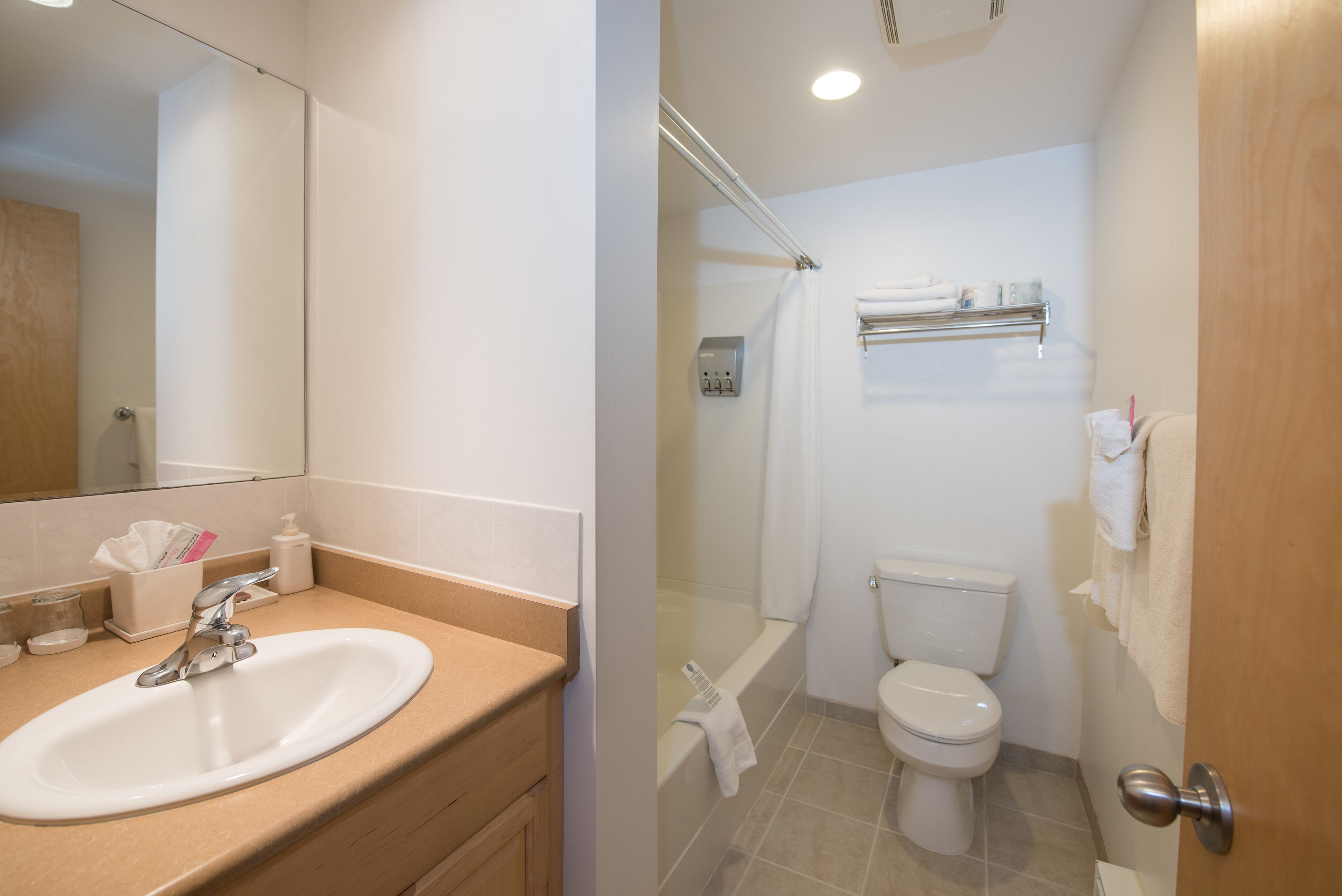 A bathroom with a sink, toilet, and shower.