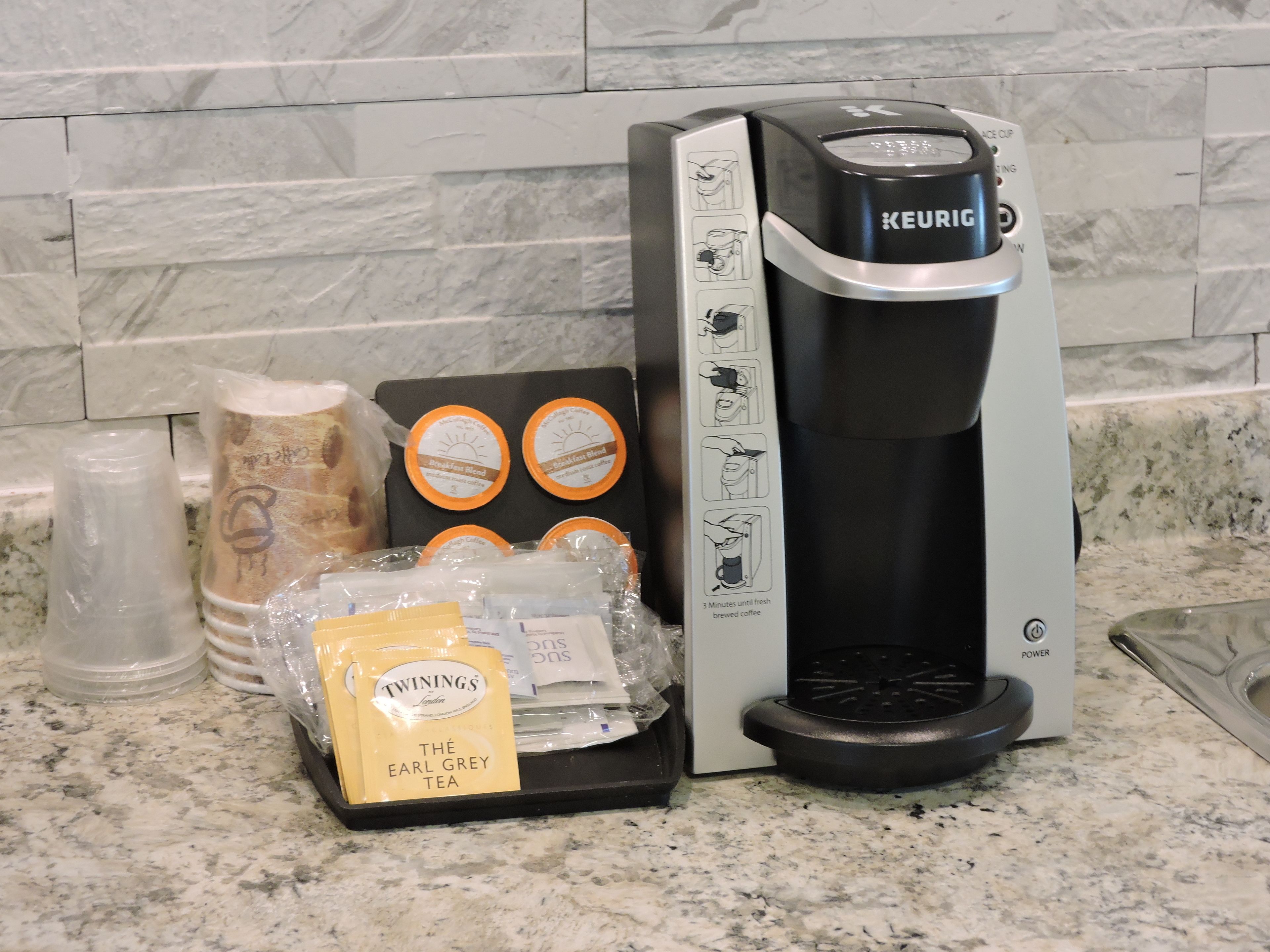 A Keurig coffee maker with a coffee pod holder and a bag of Twinings Earl Grey tea.