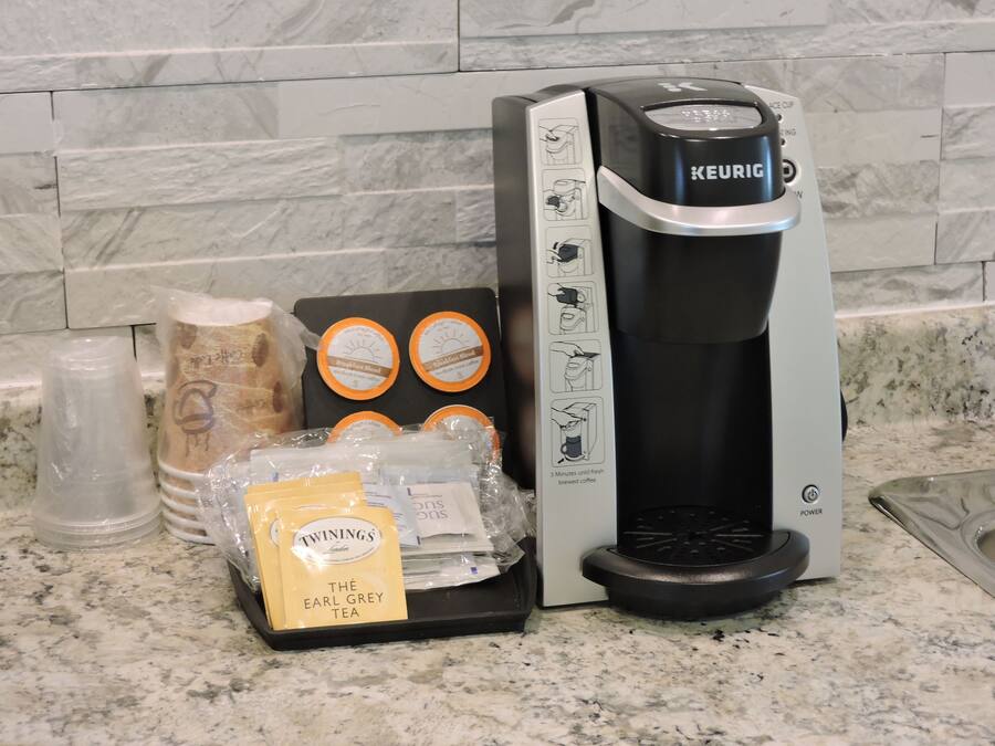 A Keurig coffee maker with a coffee pod holder and a bag of Twinings Earl Grey tea.