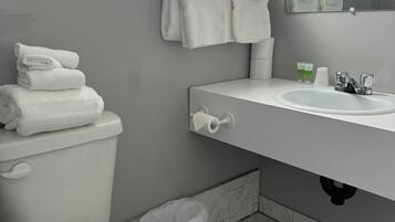 A modern bathroom with a toilet, sink, and a mirror.