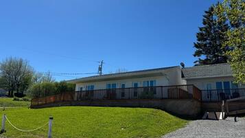 Un edificio con tetto piatto, un portico coperto e un vialetto sterrato.