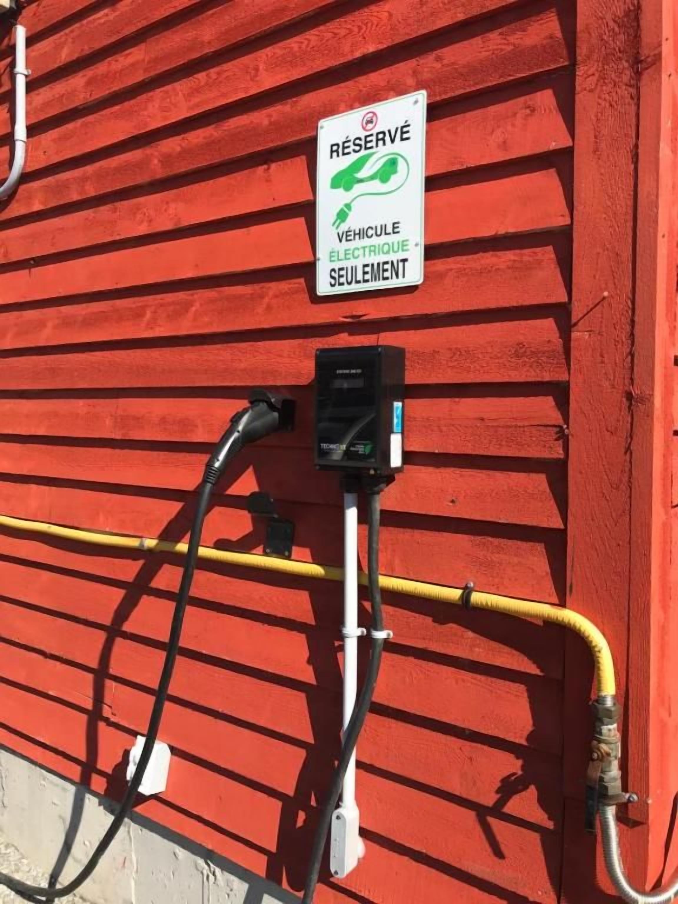 A charging station with a sign indicating it is reserved for electric vehicles only.