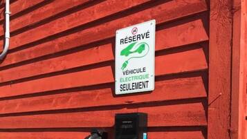 A charging station with a sign indicating it is reserved for electric vehicles only.
