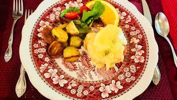 A plate with food, a fork, and a spoon on a tablecloth.