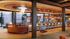 Een moderne bar met een ronde houten toonbank, hangstoelen en een bar gevuld met flessen.