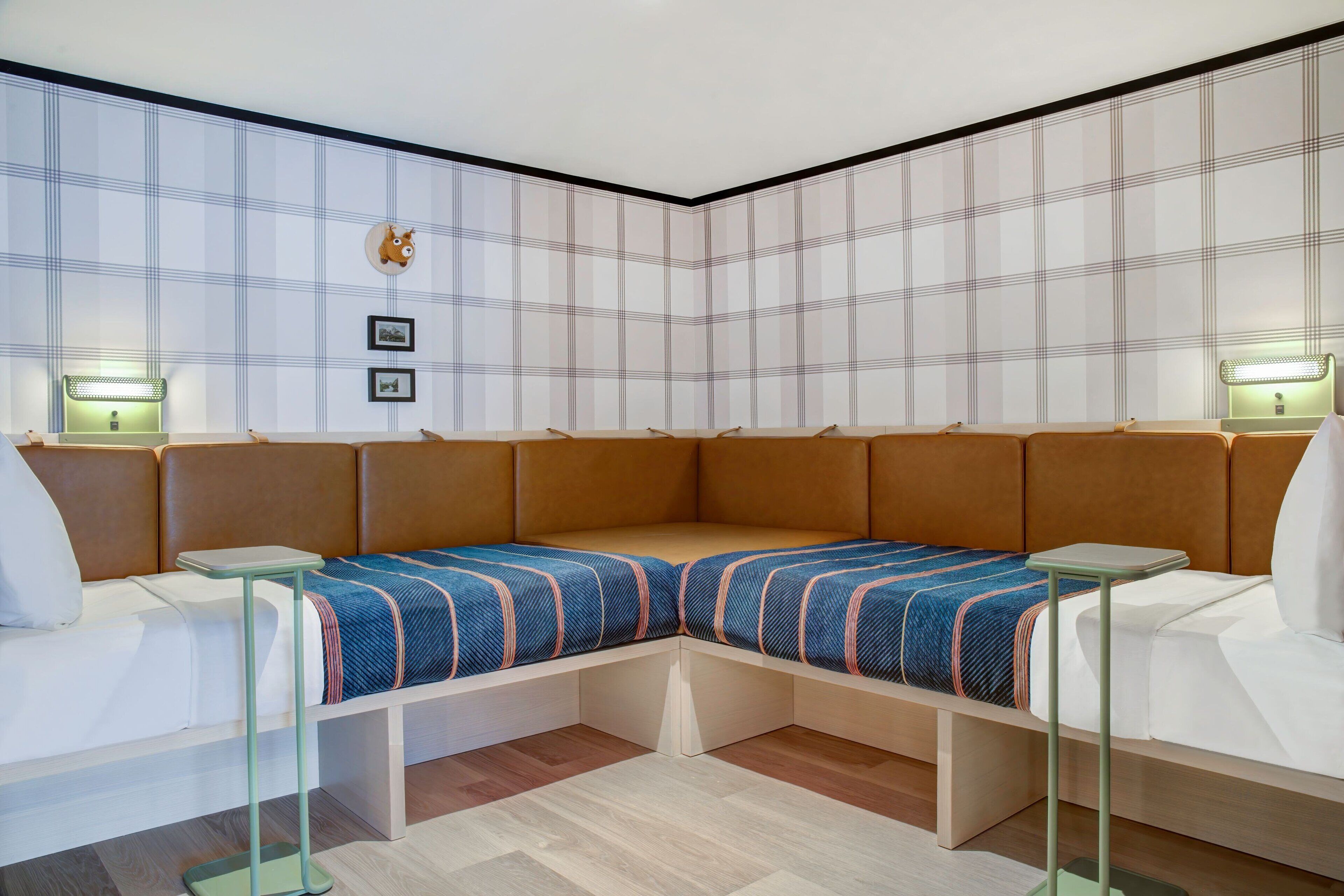 A modern room with a corner sofa, two side tables, and a wall-mounted light fixture.