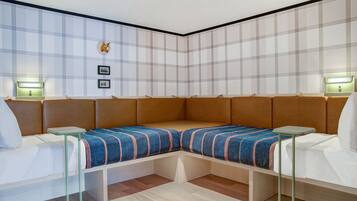 A modern room with a corner sofa, two side tables, and a wall-mounted light fixture.